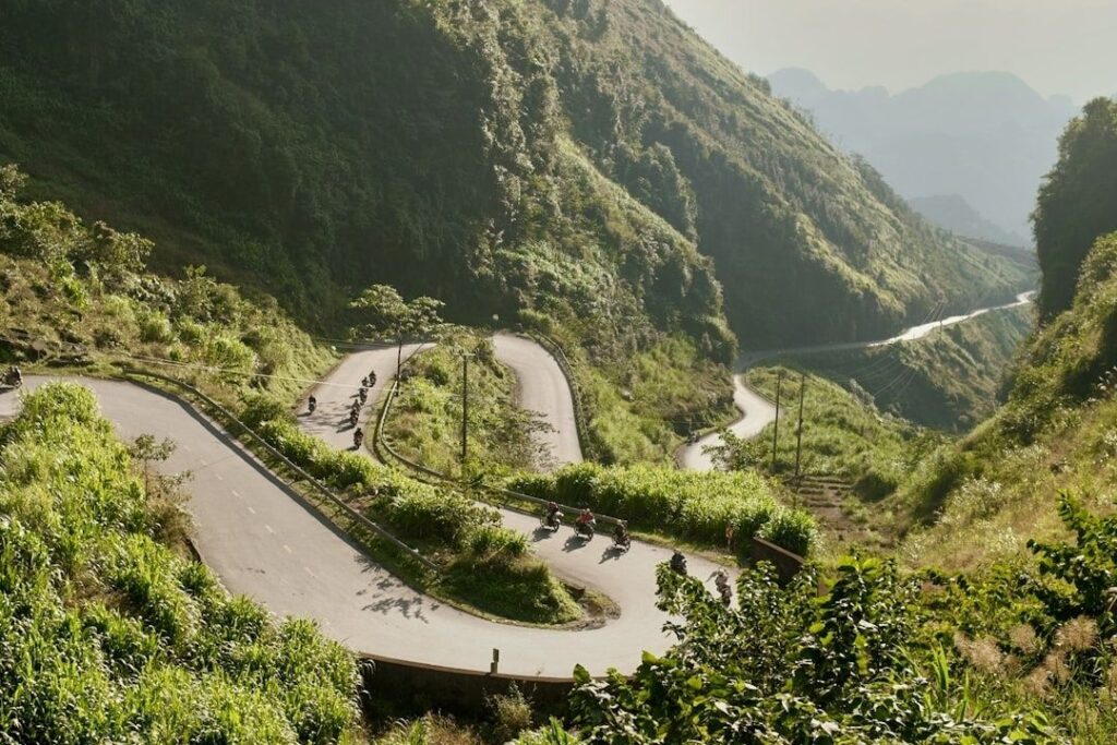 Motorcyclists riding through steep mountain switchbacks