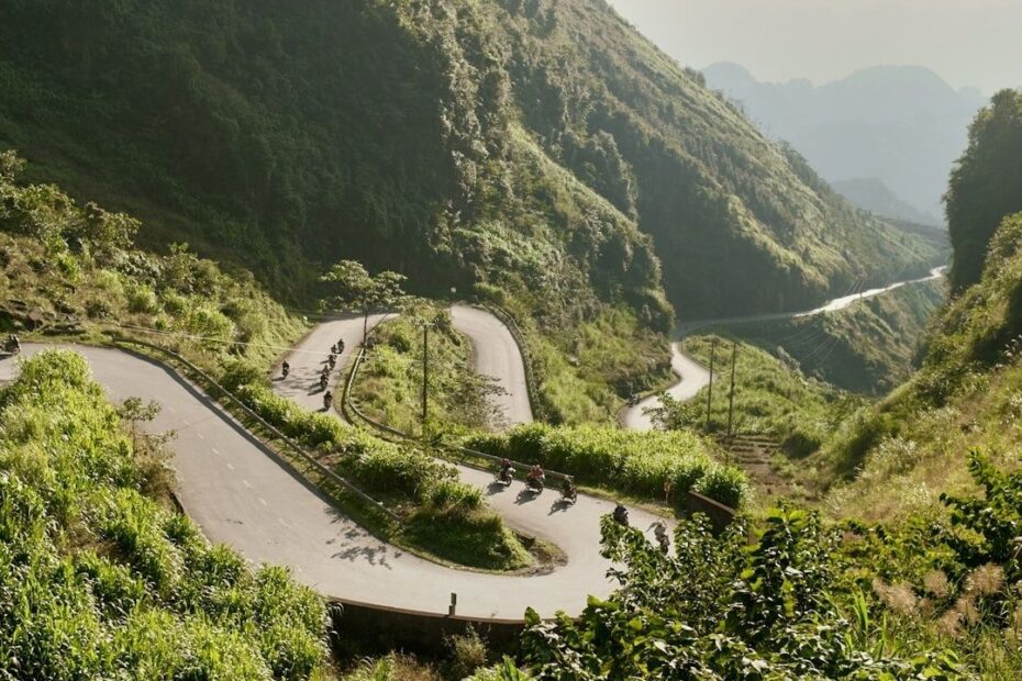 Motorcyclists riding through steep mountain switchbacks