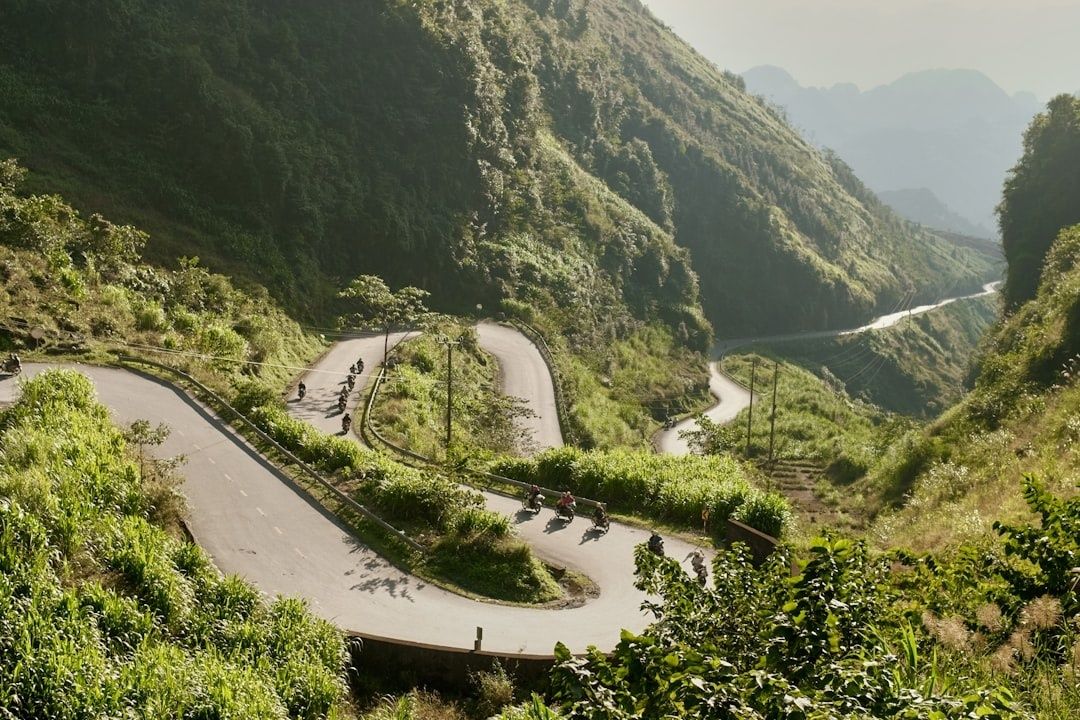Motorcyclists riding through steep mountain switchbacks